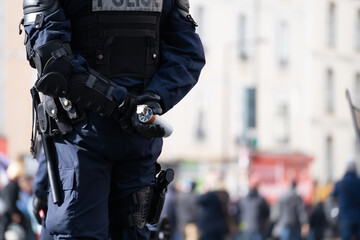 Un policier tenant une bombe lacrymogène