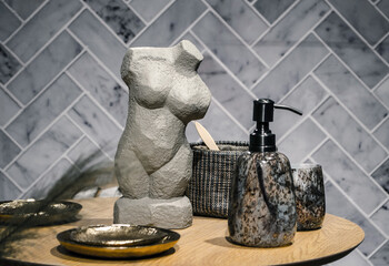 Fototapeta na wymiar Bathroom decor statue of a female figure and marble soap containers.