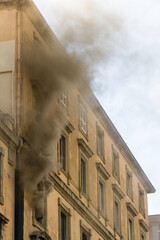 Domestic apartment fire with smoke billowing from window. Garibaldi Square, Naples, Italy