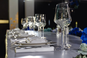 tableware Glasses, flower fork, knife served for dinner in restaurant with cozy interior