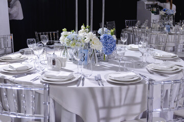 tableware Glasses, flower fork, knife served for dinner in restaurant with cozy interior