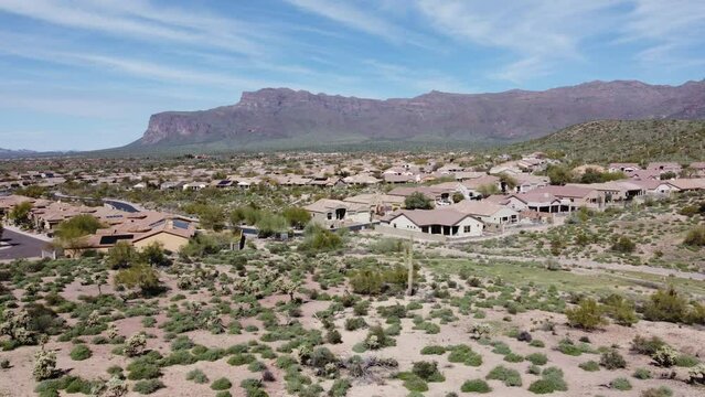 Aerial pan right across retirement community homes with desert mountains in the distance