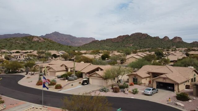 Aerial push in above desert neighborhood houses near mountains