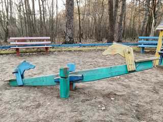 old wooden swing on the playground in the forest in the park