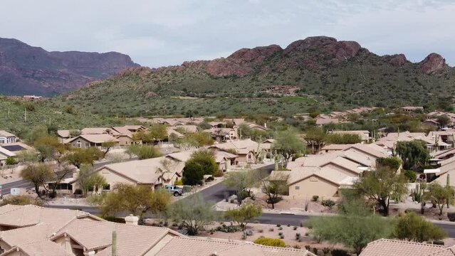 Aerial tilt up over desert retirement neighborhood near mountains