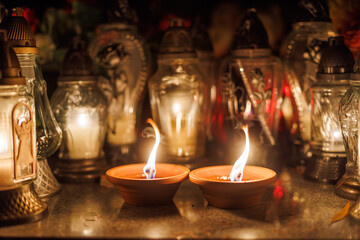 Two candles on the stone in front of the decoration in cemetry.