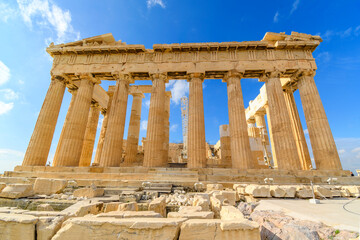 View of the ancient Greek Parthenon on Acropolis Hill in Athens, Greece with a blue sky behind.	