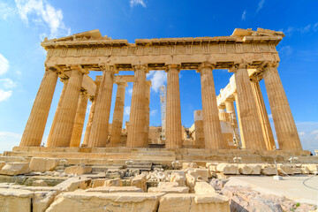 Fototapeta premium View of the ancient Greek Parthenon on Acropolis Hill in Athens, Greece with a blue sky behind. 