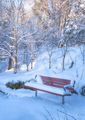 A red bench covered  in  fresh snow in local park, Gothenburg sweden