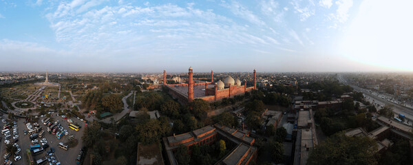 Lahore, Pakistan - December 10, 2022: An aerial 180-degree panorama of historic Badshahi Mosque, Minar-e-Pakistan, captured at dusk with a drone. 