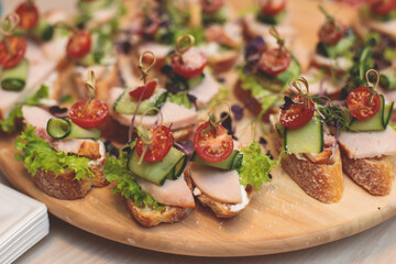Office party catering, table with variety of different food snacks on a workplace, sandwiches,...