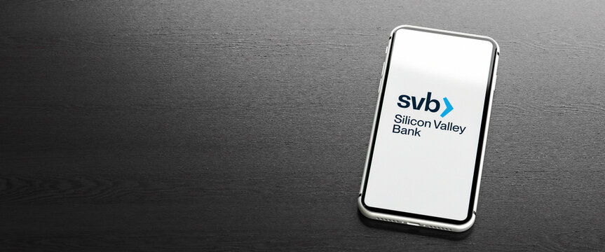 Mobile phone displaying the logo of Silicon Valley Bank  on a table. Copy space. Web banner format.