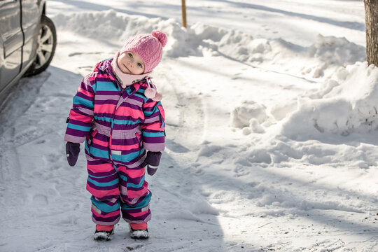 A little girl enjoys the sunny and cold winter wonderland of the north.