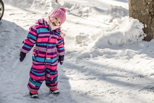 A little girl enjoys the sunny and cold winter wonderland of the north.