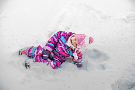 A little girl enjoys the sunny and cold winter wonderland of the north.