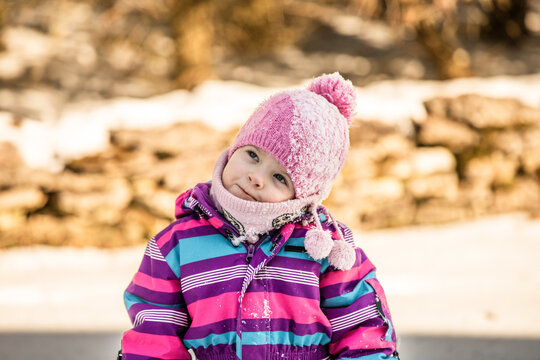 A little girl enjoys the sunny and cold winter wonderland of the north.