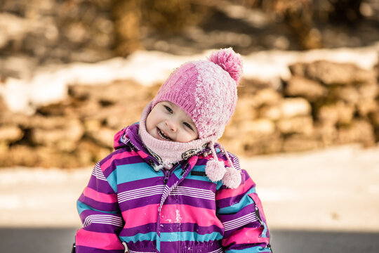 A little girl enjoys the sunny and cold winter wonderland of the north.