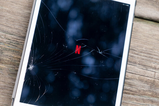 Madrid, Spain. 03-07-2023: Cracked screen of an ipad with the Netflix logotypo.