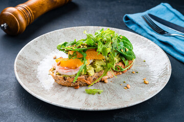 Bruschetta with shrimp, avocado, orange, arugula, spinach, parsley and pistachios.