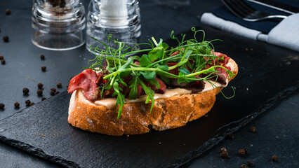 Bruschetta with beef slices, arugula, green peas and sauce.