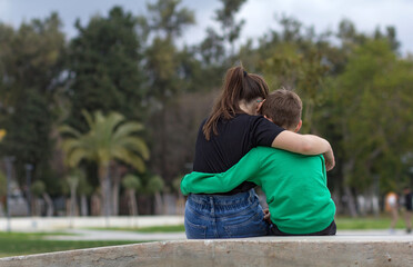 Fototapeta na wymiar The boy and the girl sit in an embrace. Friendship. Relationship.
