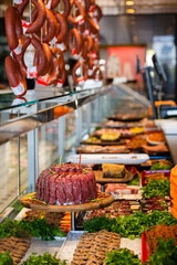 Meat department, showcase with variety of meat in different cuts. Inside an supermarket. Different types of fresh meat arranged in an orderly manner.
