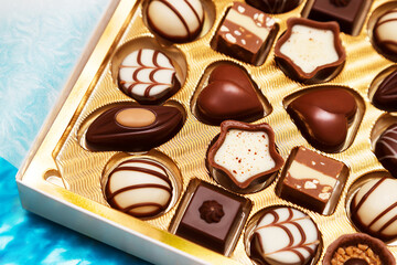 Close up of open small gift box of Swiss chocolate candies. Luxurious selection of milk, dark and white miniature masterpieces