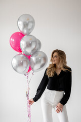 Fototapeta premium Smiling blonde woman with balloons isolated on white. Girl with braces. Orthodontics treatment.