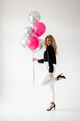 Smiling blonde woman with balloons isolated on white. Girl with braces. Orthodontics treatment.