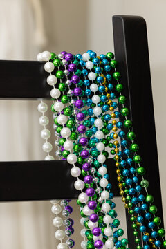 Colliers de St-Patrick sur chaise brune et rideaux blancs Mardi Gras, New Orleans, 