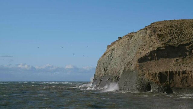 Olas rompiendo contra macizo de tierra 