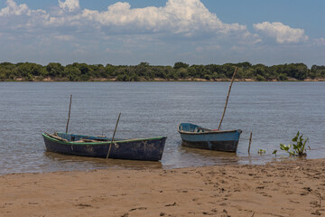 Two canoes moored on the river bank.