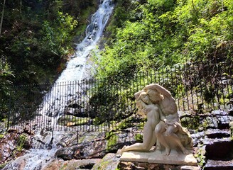 Po&ccedil;os de Caldas, Minas Gerais, Brazil - February 24, 2023. View of the waterfall and the statue of two young people embracing at the Fountain of Love.