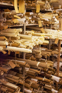 Archive room filled with county maps and rolled up scrolls of old building designs and boundaries. 