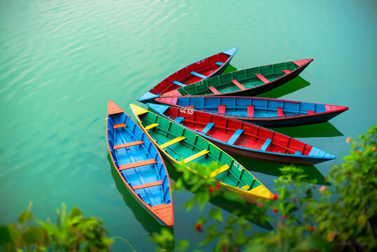 Colorful Wooden Row Boats in glacial Napal lake in many bright colors