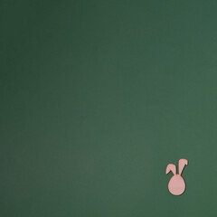 Rabbit ears in the downer right on a green background with copy space. Minimal flat lay Easter scene.