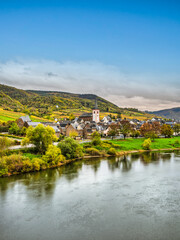 Fototapeta na wymiar Bruttig-Fankel village on moselle river bank and colourful vineyards during autumn in Cochem-Zell, Germany