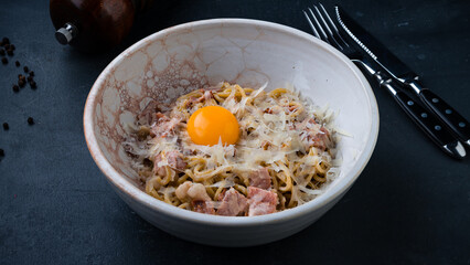 Lunch pasta with ham, parmesan cheese and raw egg.