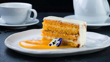 Piece of carrot cake with cream cheese and sweet sauce.