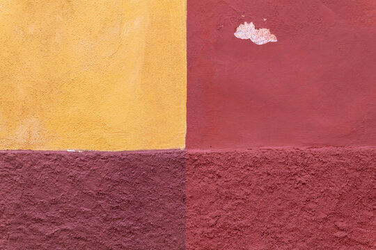 Colorful Mexican exterior wall painted in tri colors and CENTERED, distressed textures