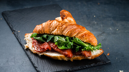 Fresh croissant with sun-dried tomatoes, cream cheese, spinach and arugula.