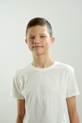 adult boy teenager 13-15 years old stands he looks into frame lop-eared ears narrow eyes oriental Asian neat hairstyle dark black hair