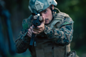 Obraz premium A modern warfare soldier on war duty in dense and dangerous forest areas. Dangerous military rescue operations