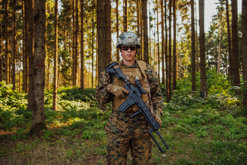 Fototapeta premium A modern warfare soldier on war duty in dense and dangerous forest areas. Dangerous military rescue operations