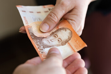 Chile 20 thousand pesos, banknote, Passing money from hand to hand, Financial and business concept, Chile's highest denomination banknote, Passing cash to each other - obrazy, fototapety, plakaty