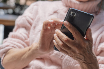 Mujer de la tercera edad interactuando con su celular
