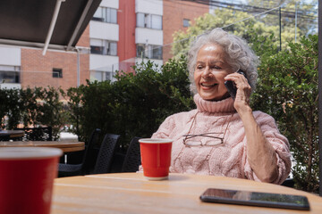 Mujer feliz en restaurante llamando por teléfono