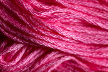 A close up view of bright pink thread is suggestive of easter eggs, flowers, and bubble gum.