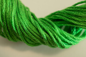 A textured twist of green thread brings to mind crafts of knitting, embroidery, and sewing.