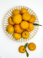 Orange fruit with green leaves on the white background. Home gardening. Mandarine oranges. Tangerine oranges. Orange color. Fresh orange juice.